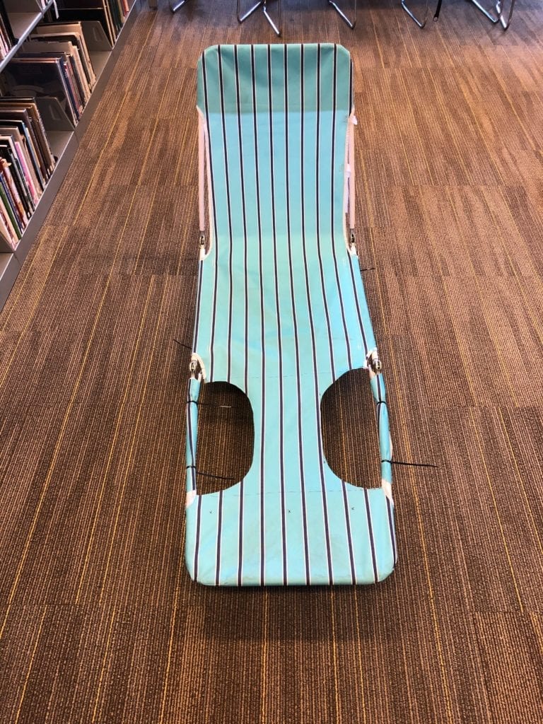 Preliminary Seat Prototype. A folding beach chair strapped to a dolly.